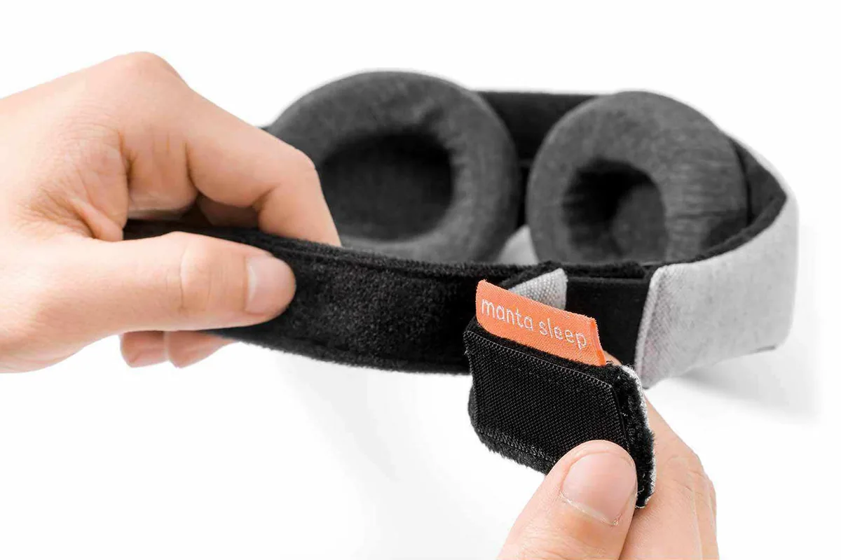 Hands adjusting the removable eye cups on a Manta sleep mask strap
